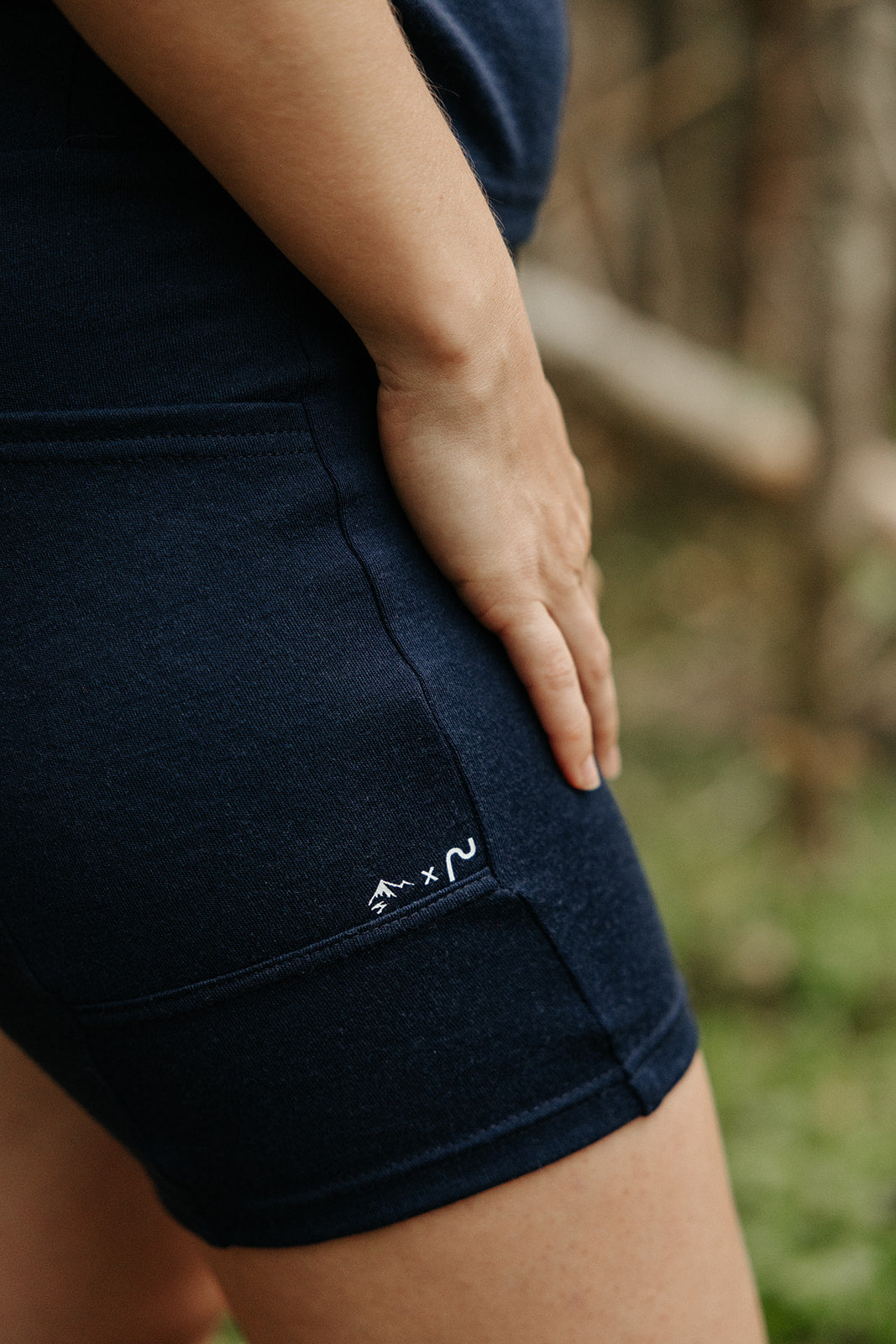 Biker short en laine de mérinos marine pour femme avec poche latérale pratique, porté lors d'une activité en plein air.