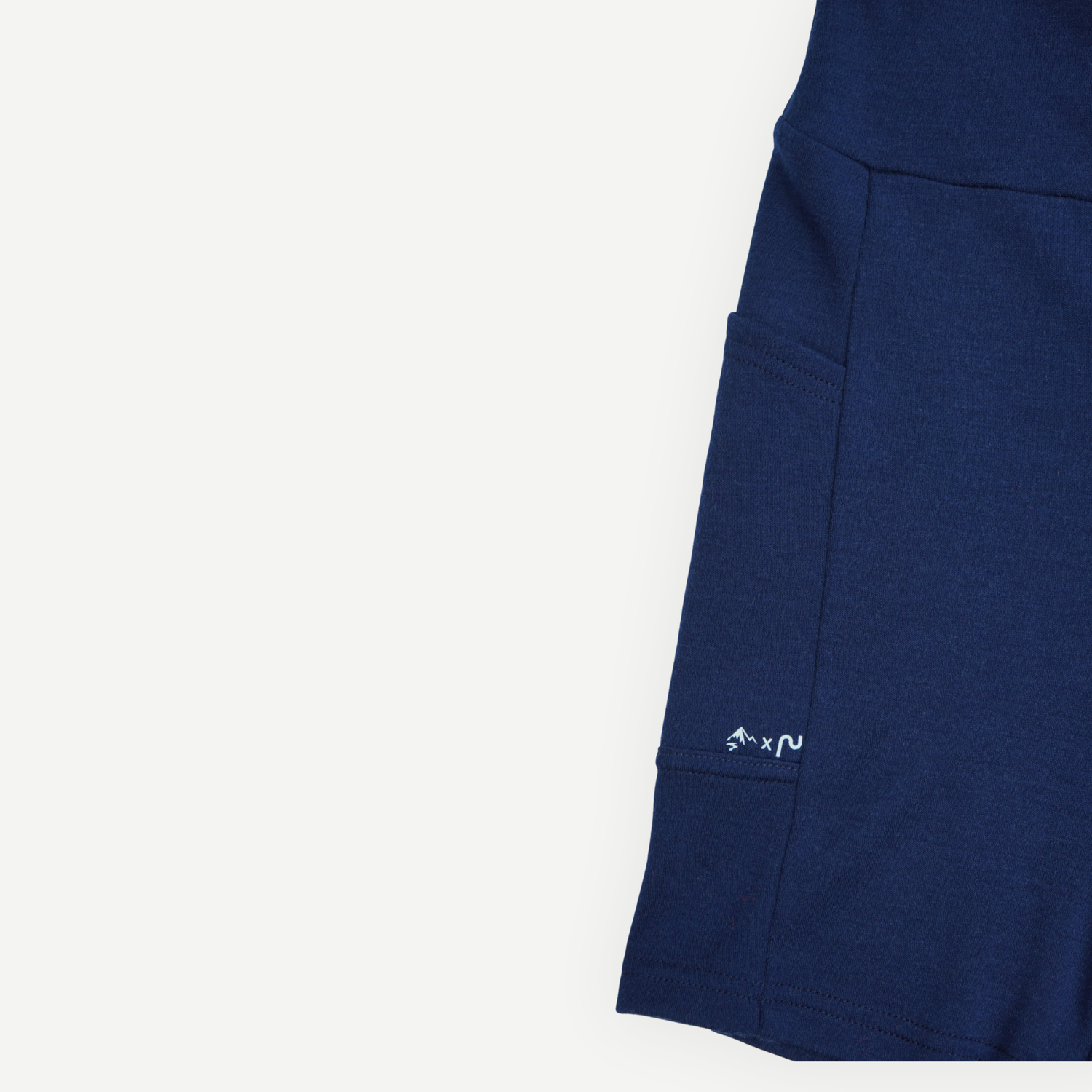 Détail de la poche latérale du biker short en laine de mérinos marine pour femme, collection Périple x Activmom.