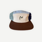 Casquette en coton à 5 panneaux de la marque Périple. Modèle colorblock sauge, crème et marine avec visière brun cacao, vue de face.