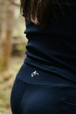 Détail du legging ActivMom x Périple en laine de mérinos marine montrant le logo de Naomie Veillette à l'arrière de la taille. 