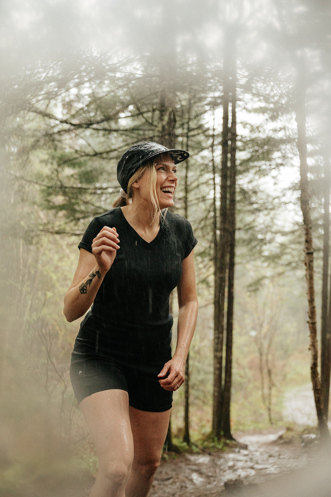 Femme portant un t-shirt col V et un biker short en laine de mérinos Ardoise lors d'une randonnée sous la pluie en forêt.
